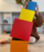 Child stacking wooden boxes